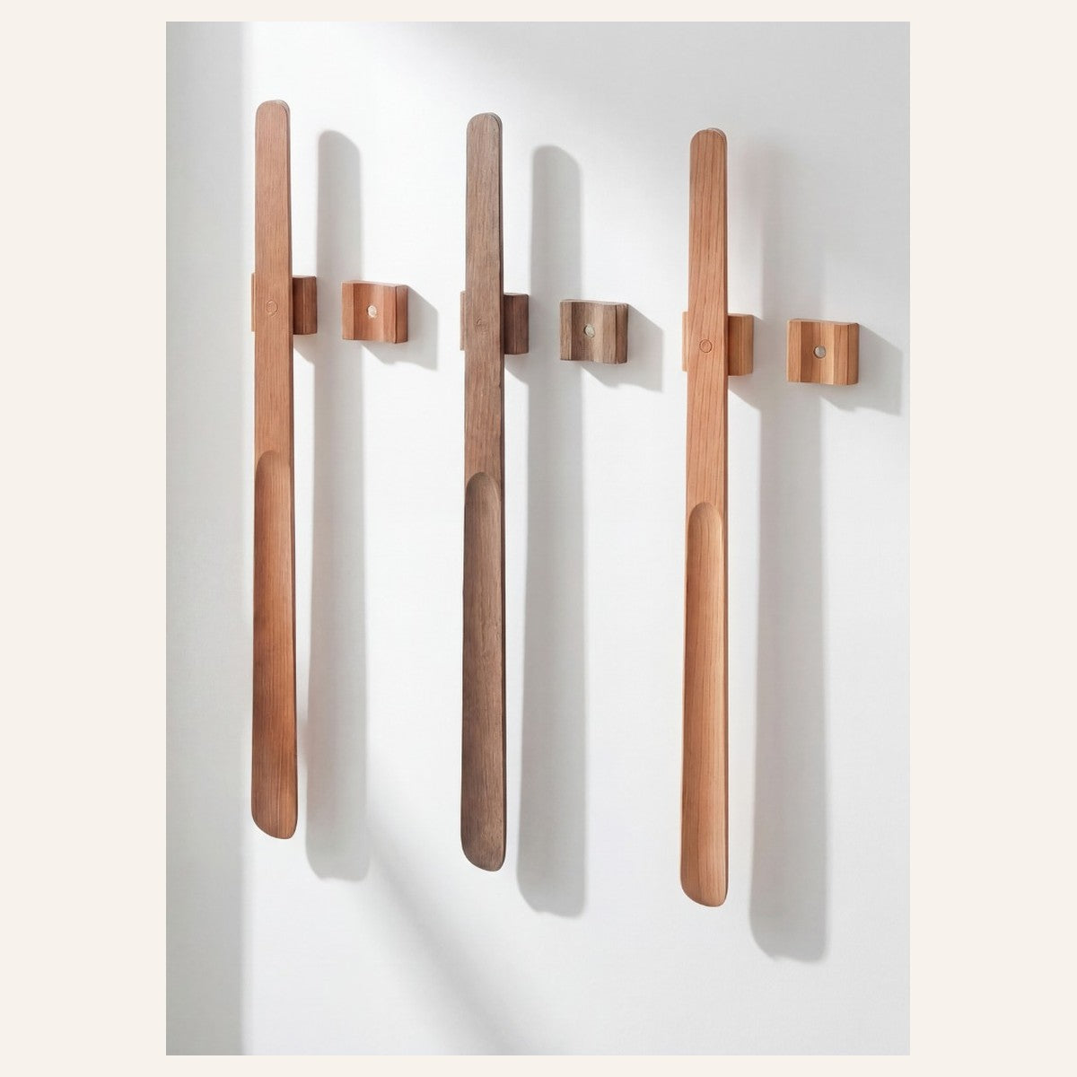 Norlund magnetic shoehorn in four wood finishes on a wall with magnetic mounts