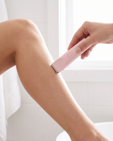 A woman using the Rosava soft rose body trimmer to shave her smooth lower leg