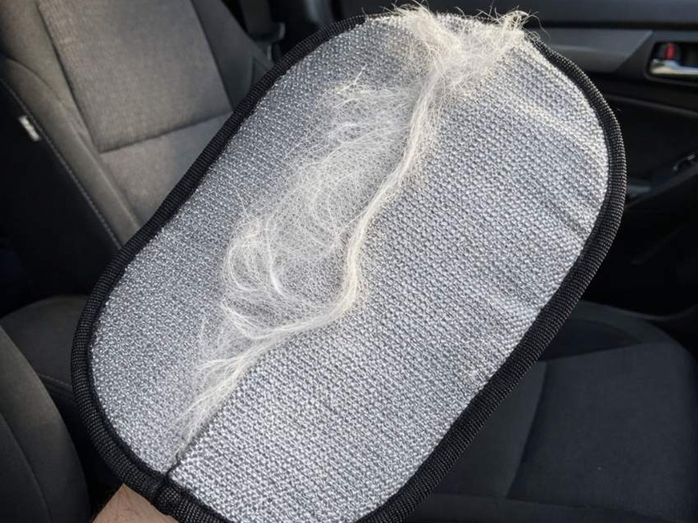 Furvia glove on dark car-seat fabric
